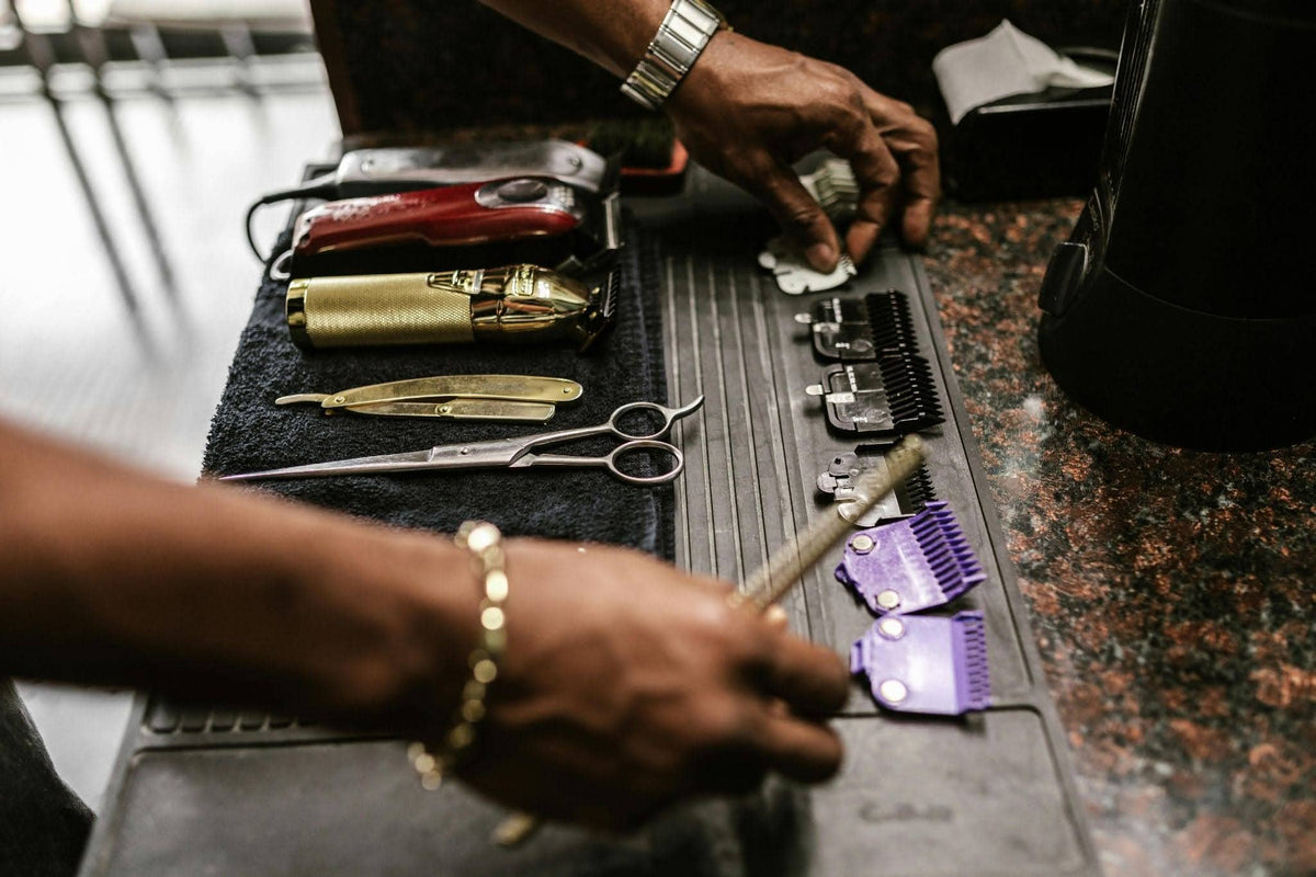 A professional groomer organising dog grooming clippers, scissors, and clipper blades on a salon table,  illustrating a structured grooming blade maintenance and tool management setup in a professional pet grooming salon